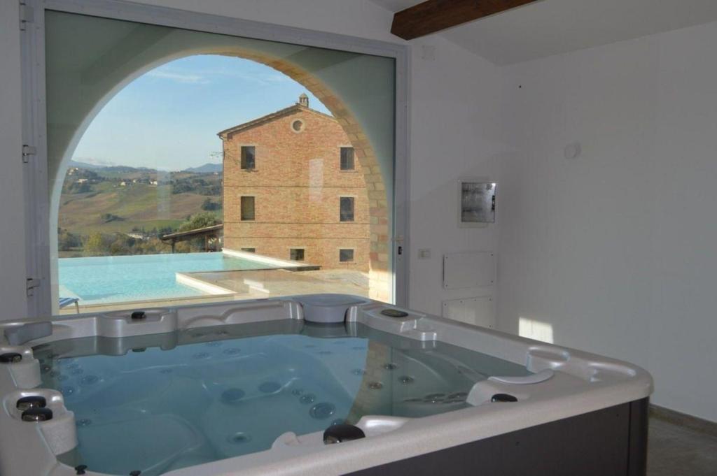baño grande con bañera y ventana grande en Ferienhaus mit Privatpool für 12 Personen ca 350 qm in Loro Piceno, Marken Provinz Macerata, en Loro Piceno