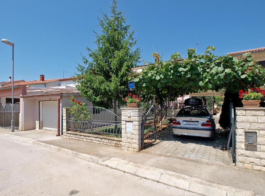 un coche aparcado bajo un arco con un árbol en Ferienwohnung für 5 Personen ca 82 qm in Fažana, Istrien Istrische Riviera, en Fažana