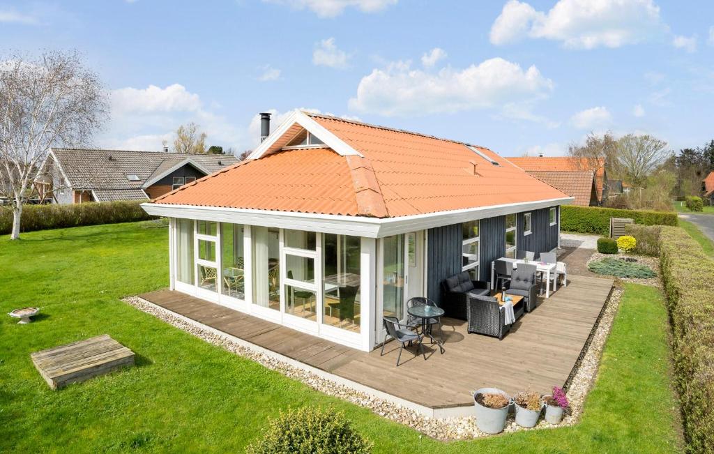 una casa con techo naranja y terraza en Stunning Home In Juelsminde With Wifi, en Sønderby