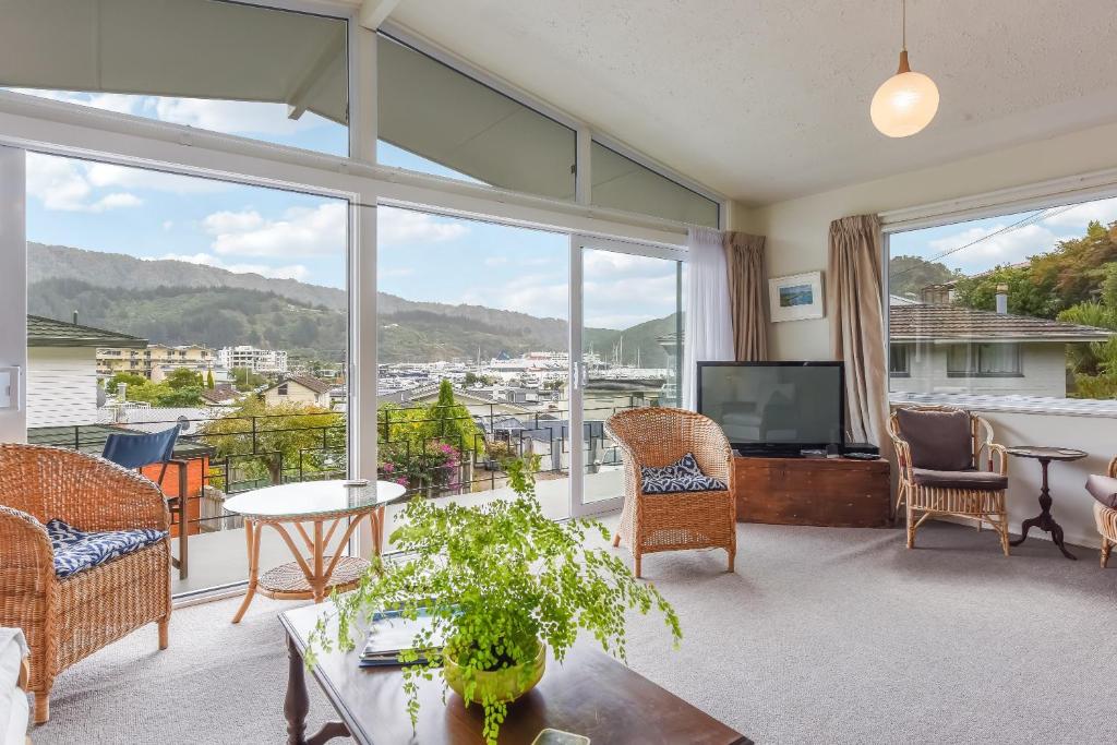 a living room with a large window and a tv at Sunny Seaview House 5 minute walk to town in Picton