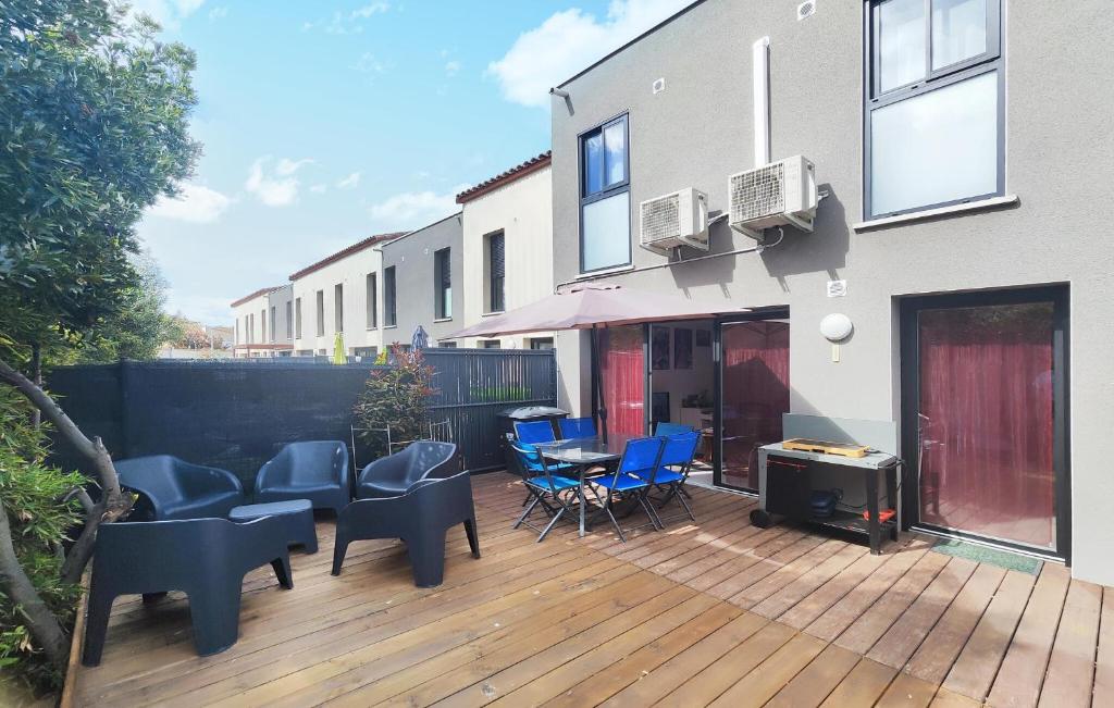 a wooden deck with chairs and a table on a house at 3 Bedroom Gorgeous Home In Agde in Agde