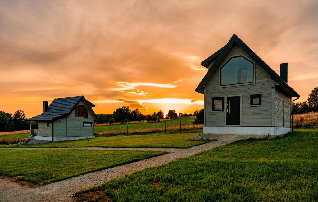 une maison dans un champ avec un coucher de soleil en arrière-plan dans l'établissement Lovely Home In Sierpnica With Wifi, à Sierpnica