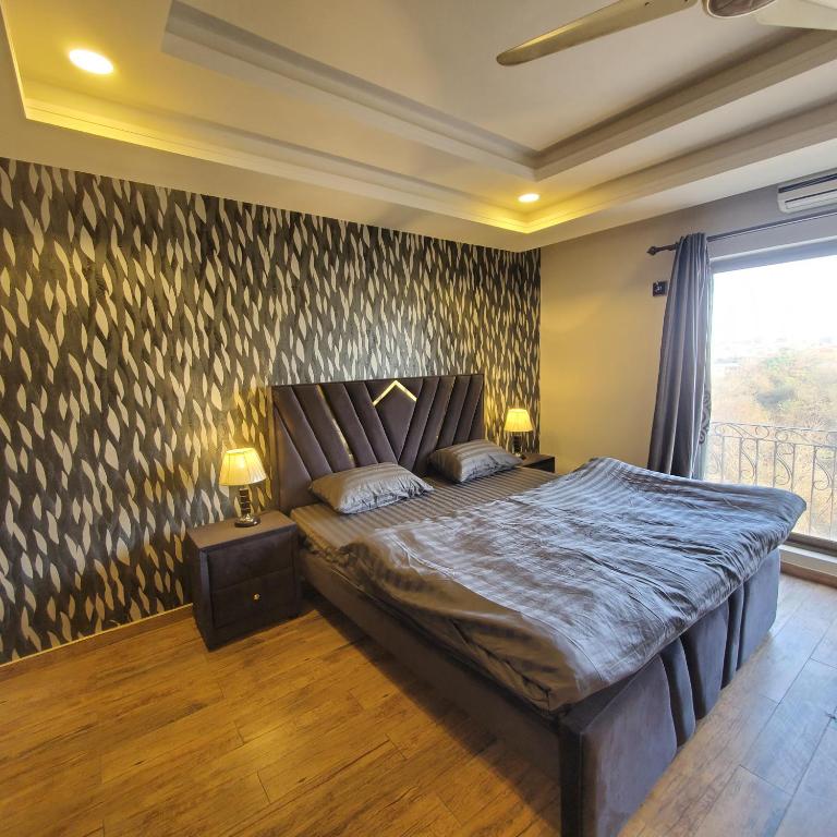 een slaapkamer met een bed en twee nachtkastjes met lampen bij Bahria Paradise in Rawalpindi