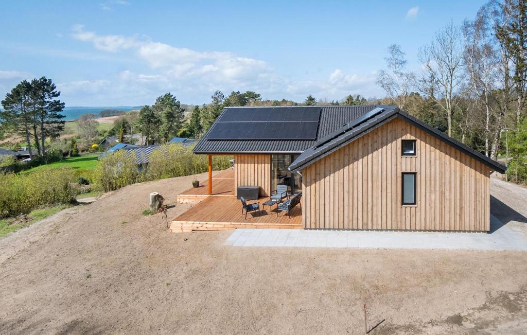 uma pequena casa com um telhado solar num campo de terra em Gorgeous Home In Millinge With House Sea View em Millinge