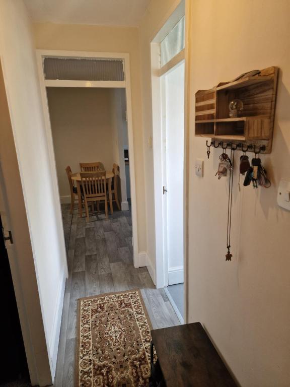 a hallway with a room with a table and a rug at Cosy Hadleigh in Hadleigh