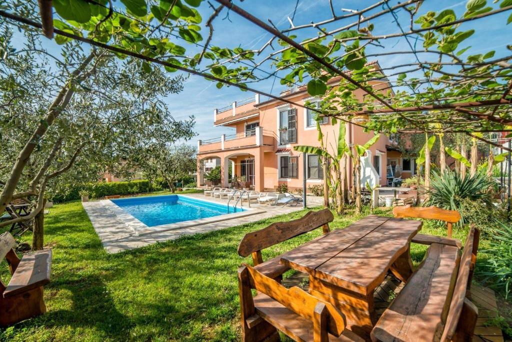 普拉的住宿－Ferienwohnung für 4 Personen ca 40 qm in Pula, Istrien Istrische Riviera - b54489，一个带木桌和椅子的后院和一个游泳池