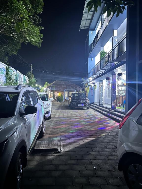 un groupe de voitures garées dans une rue la nuit dans l'établissement Wayanad Vista Service Apartment, à Wayanad