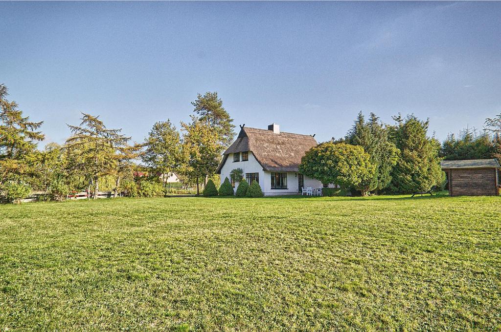 una casa blanca con un gran campo de hierba en Reetdachhaus mit großem Garten und Kamin, en Marlow