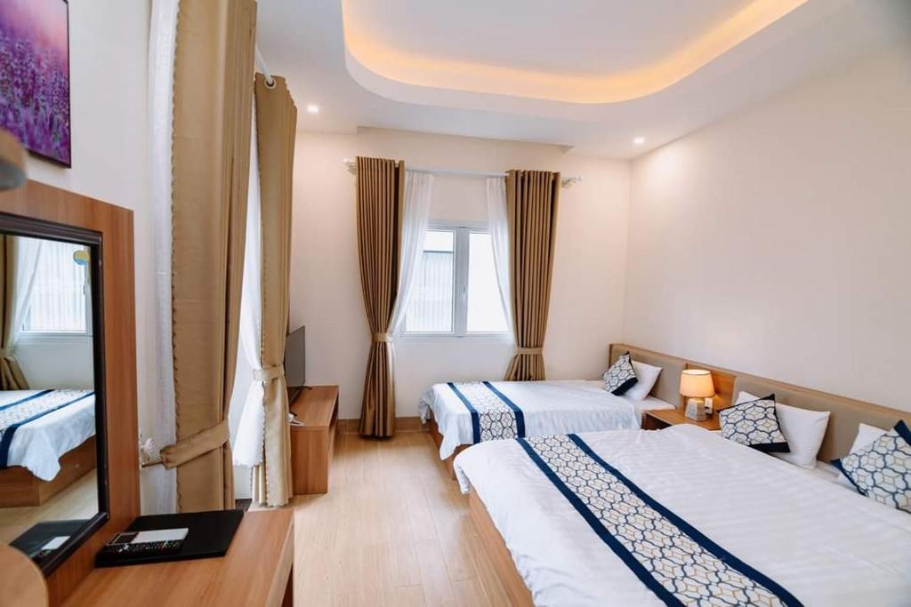 um quarto de hotel com duas camas e uma janela em Vân Dương hotel em Kon Von Kla