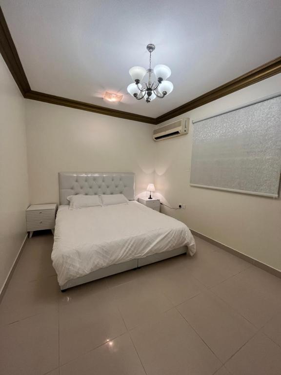 una camera con letto bianco e proiettore di Lama a Riyad