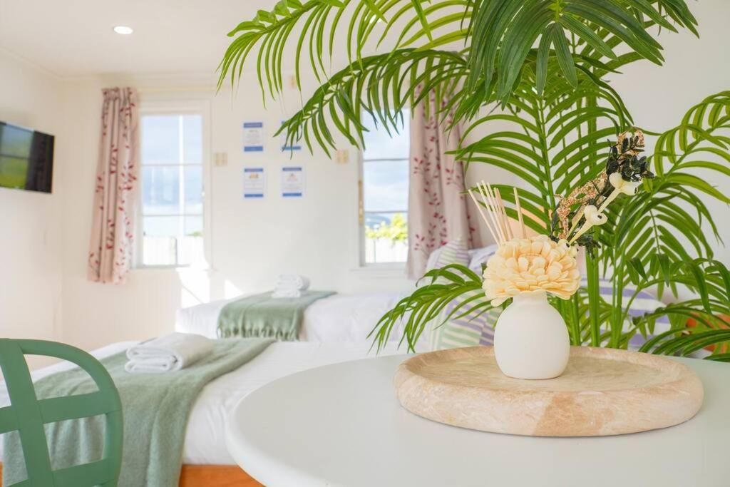 Una mesa blanca con un jarrón con flores. en 5-Bedroom Fully-Equipped Home in Whangarei, en Whangarei