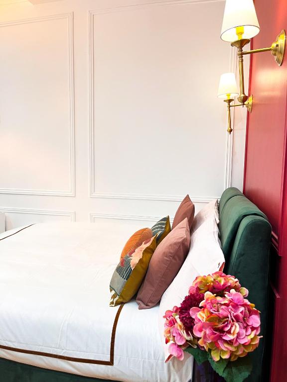 - un lit avec des oreillers et des fleurs dans l'établissement Studio Design Chic Central Paris, à Paris