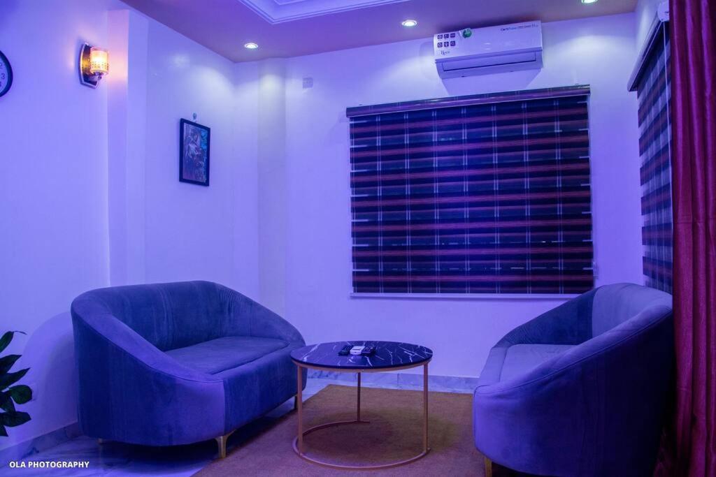 2 sillas azules y una mesa en una habitación en One bedroom oluwa-sheyi-apartment, en Cotonou