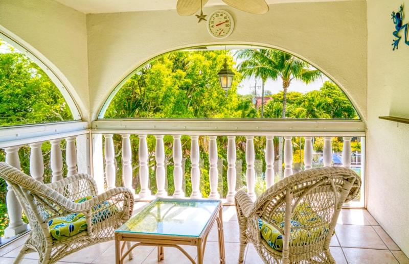 a balcony with wicker chairs and a glass table at Breakers West C1 condo in Sanibel