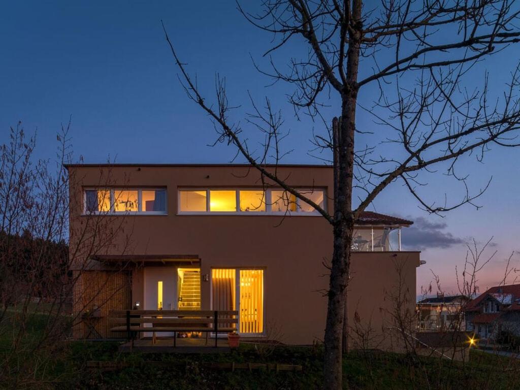 una casa con sus ventanas iluminadas por la noche en Ferienhaus Sandra en Hörbranz