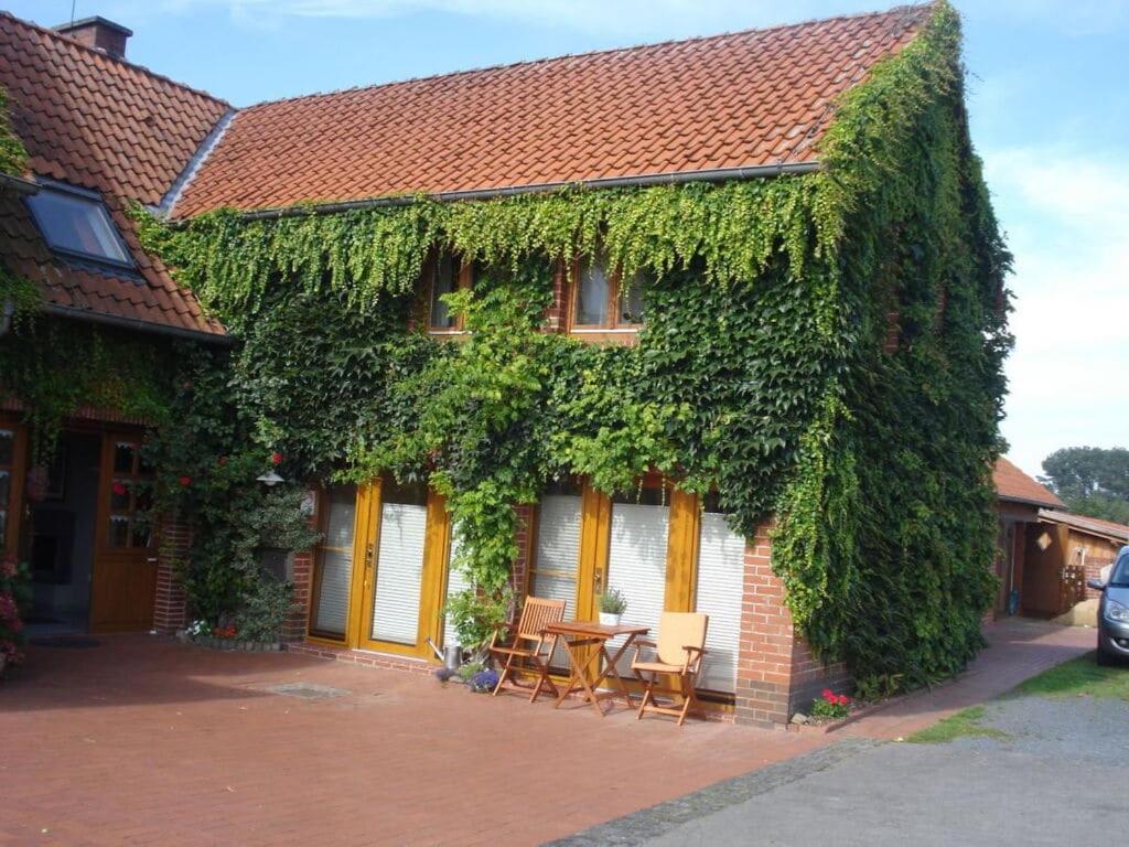 una casa cubierta de hiedra con mesa y sillas en Türnau Modern retreat, en WÃ¶lpinghausen