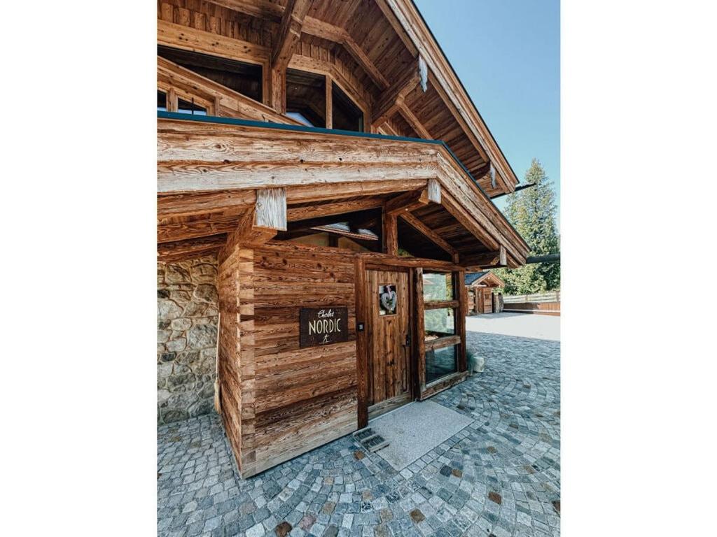 un edificio de madera con un cartel en la puerta en Chalet Nordic Modern Retreat, en Bayrischzell