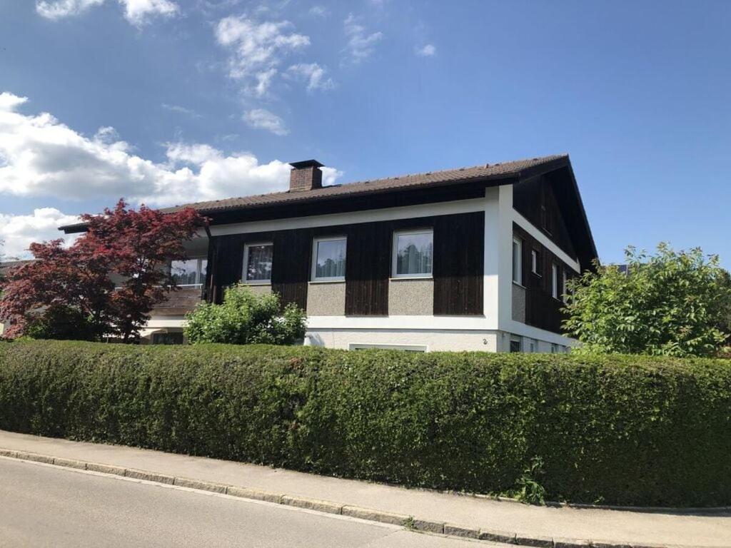ein schwarzweißes Haus mit Hecke in der Unterkunft Family Apartment Bavaria in Füssen