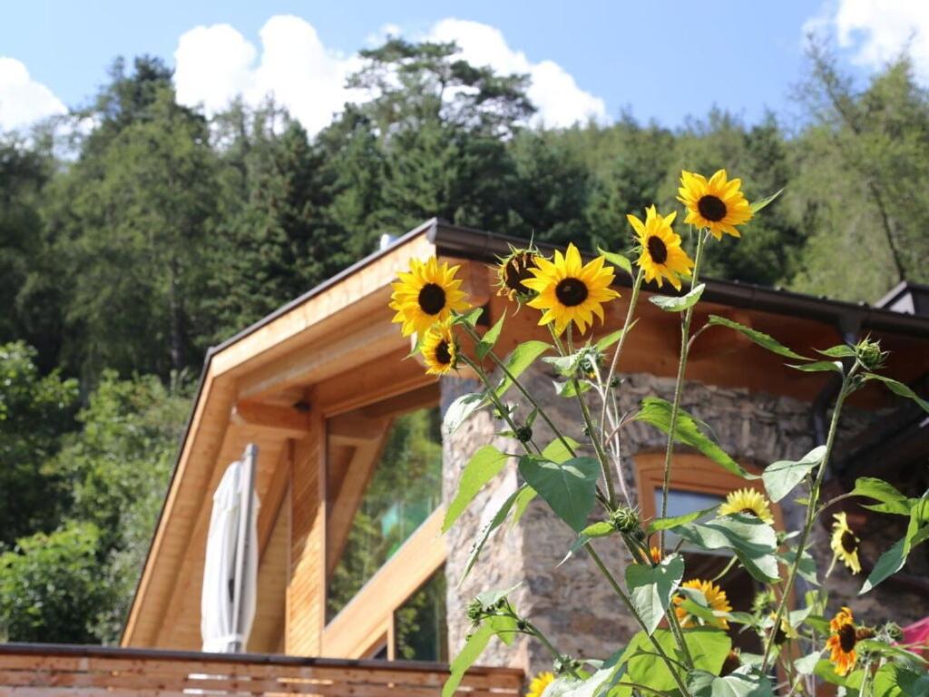 een bos zonnebloemen voor een gebouw bij hoamisch Modern retreat in Malles Venosta