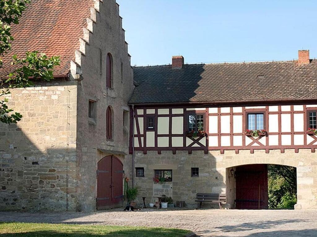 an old building with a gate and a stone building at with tower Modern retreat in Scheinfeld