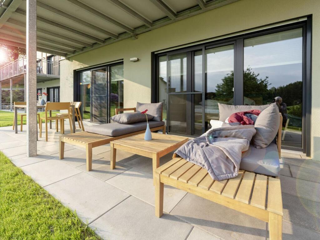 a patio with couches and tables and windows at STAY4 2 Modern retreat in Wunsiedel