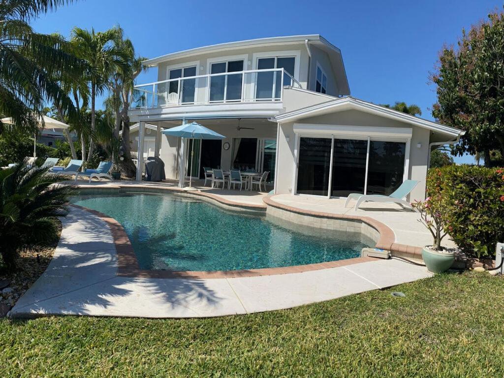 a house with a swimming pool in front of a house at Villa Bayside Beach in Fort Myers Beach