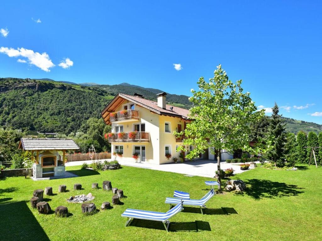 una casa con un patio con tumbonas en el césped en Eisackblick Modern retreat en Brixen