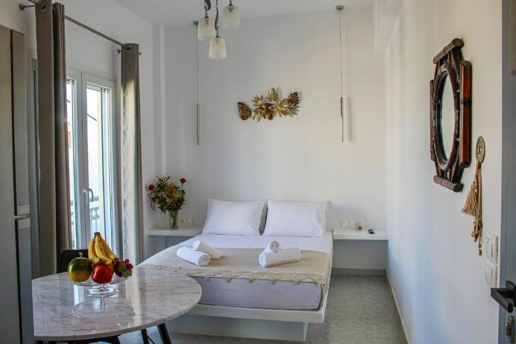Habitación blanca con cama y mesa en Aegean Pearl Studio, en Tinos
