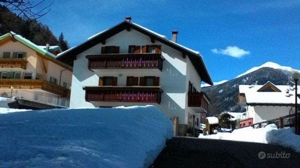 a large building with snow in front of it at Ferienwohnung für 8 Personen ca 95 qm in Pellizzano, Trentino Val di Sole in Pellizzano