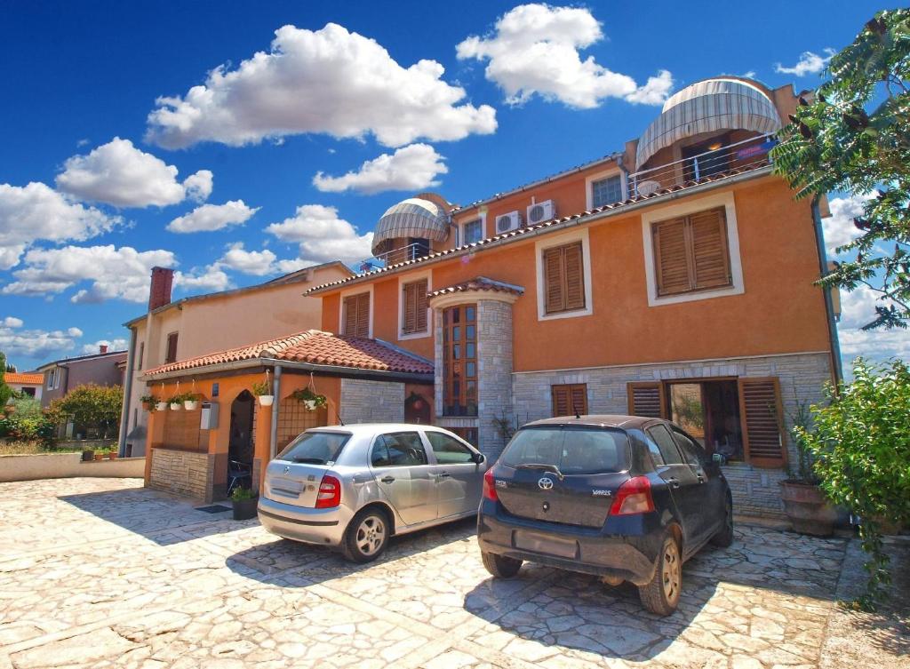 two cars parked in front of a house at Ferienwohnung für 4 Personen ca 40 qm in Fažana-Surida, Istrien Istrische Riviera - b54424 in Valbandon