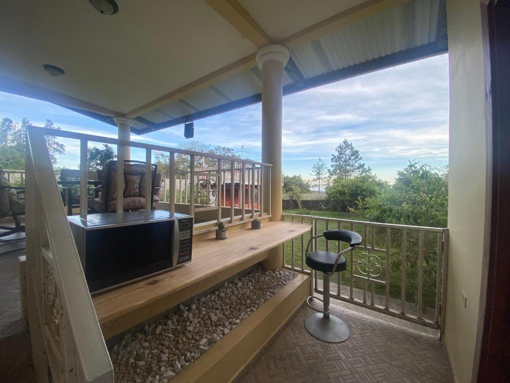 una veranda protetta con una televisione e uno sgabello di Volcano Pines Retreat ad Alto Boquete