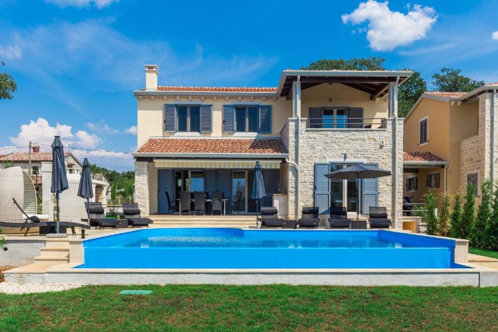 een villa met een zwembad voor een huis bij Ferienhaus mit Privatpool für 8 Personen ca 180 qm in Deklići, Istrien Istrische Riviera in Kaštelir