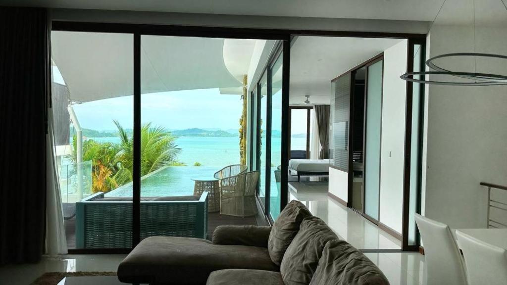 sala de estar con sofá y vistas al océano en Sunrise ocean villa, en Phuket