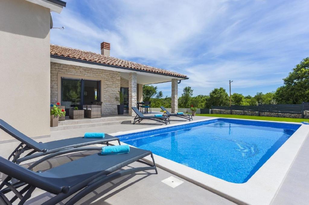a villa with a swimming pool and patio furniture at Ferienhaus mit Privatpool für 6 Personen ca 100 qm in Belavici, Istrien Bucht von Raša in Hreljići