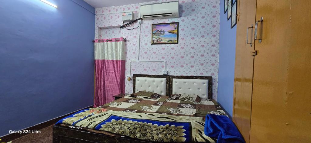 a bedroom with a bed with a purple wall at Kashi dham Homestay-Near to Temple and ghats in Varanasi
