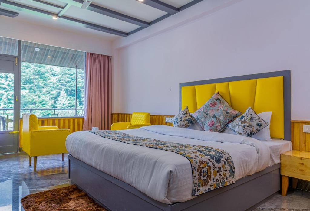 1 dormitorio con 1 cama grande y cabecero amarillo en Hotel Apple Flower, en Manali