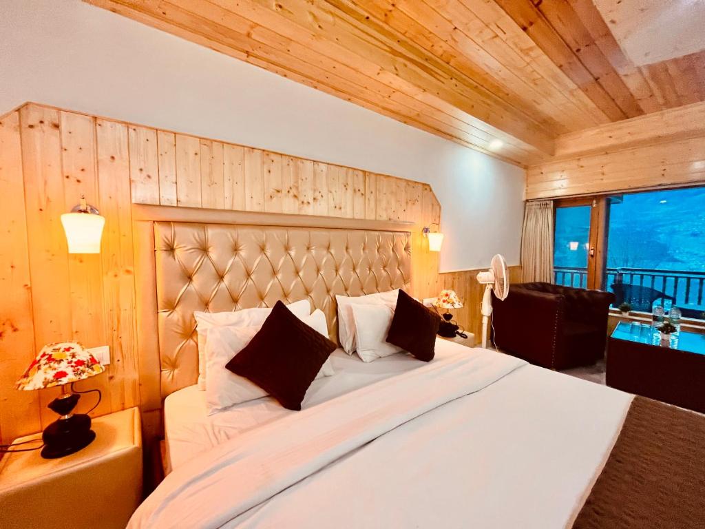 a bedroom with a large bed with a wooden wall at Pinewood Lodge in Ooty