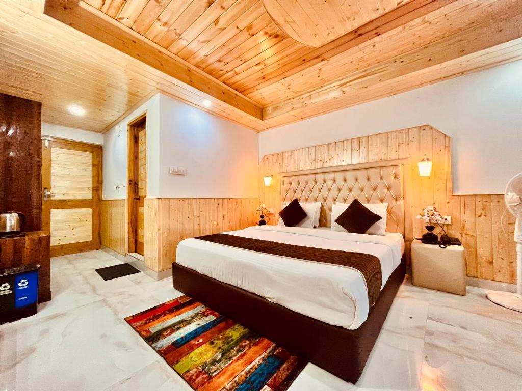 a bedroom with a large bed with a wooden ceiling at Pinerock hotel in Mussoorie
