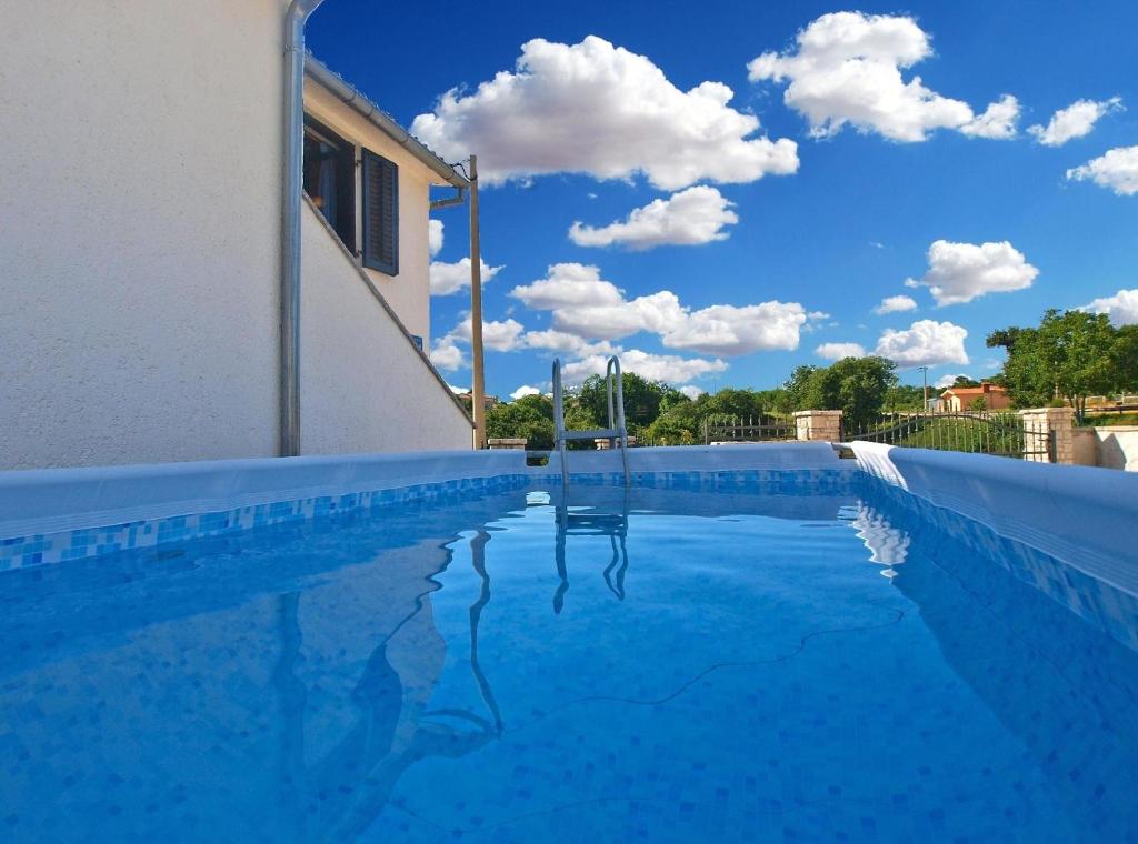 une piscine bleue avec un ciel bleu en arrière-plan dans l'établissement Ferienhaus mit Privatpool für 4 Personen ca 40 qm in Pajkovići, Istrien Binnenland von Istrien, à Pajkovići