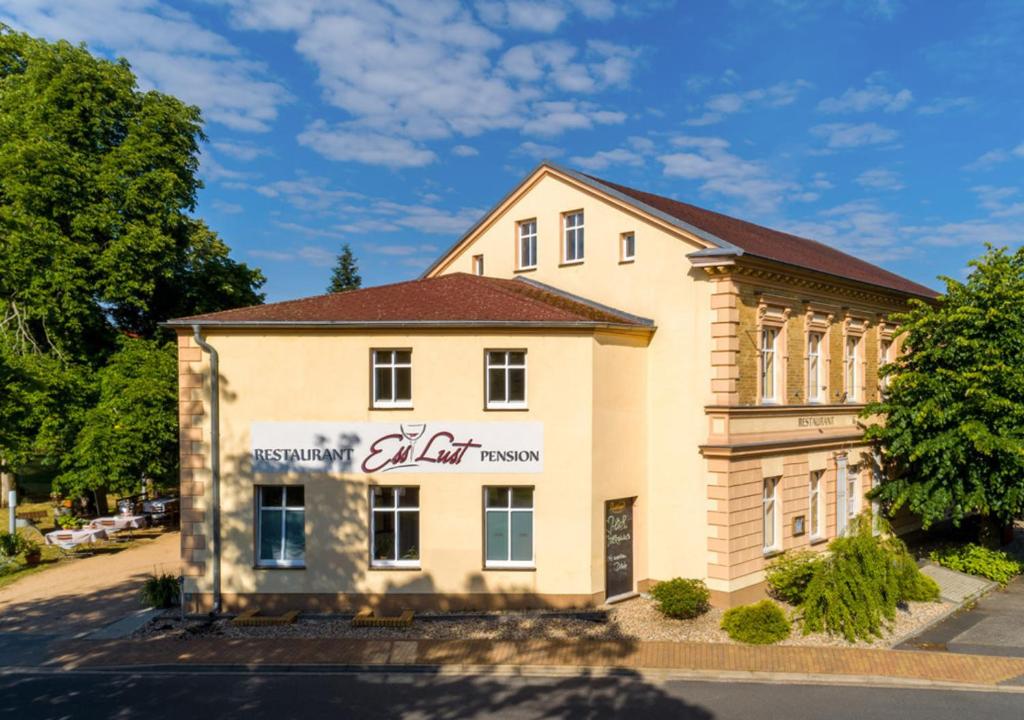 a building with a sign on the side of it at Pension EssLust in Niedergörsdorf