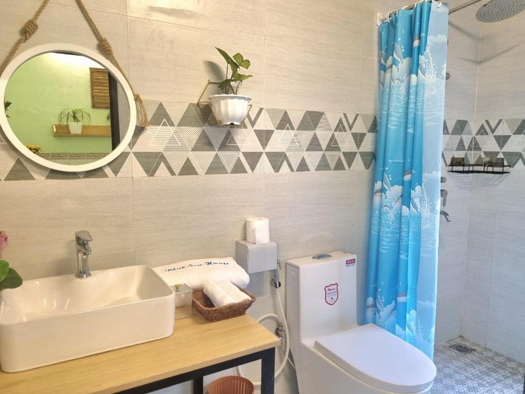 a bathroom with a sink and a toilet and a mirror at Blue Sea House Quảng Bình - Căn hộ 2 phòng ngủ, phòng khách và phòng bếp in Dong Hoi
