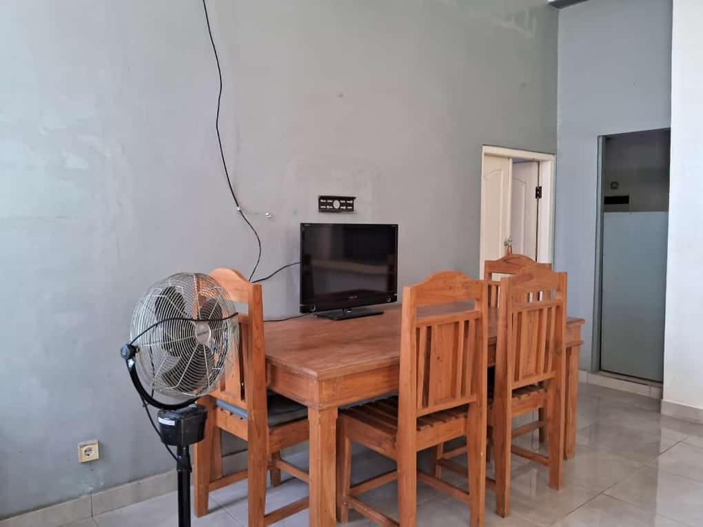 mesa de comedor y sillas con ventilador y TV en Villa Bamboo Sumbawa en Sumbawa Besar