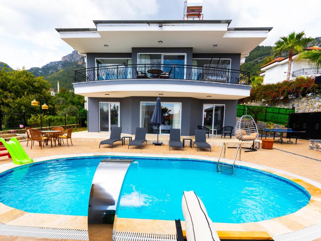 a villa with a swimming pool in front of a house at alanya polat holiday village in Alanya
