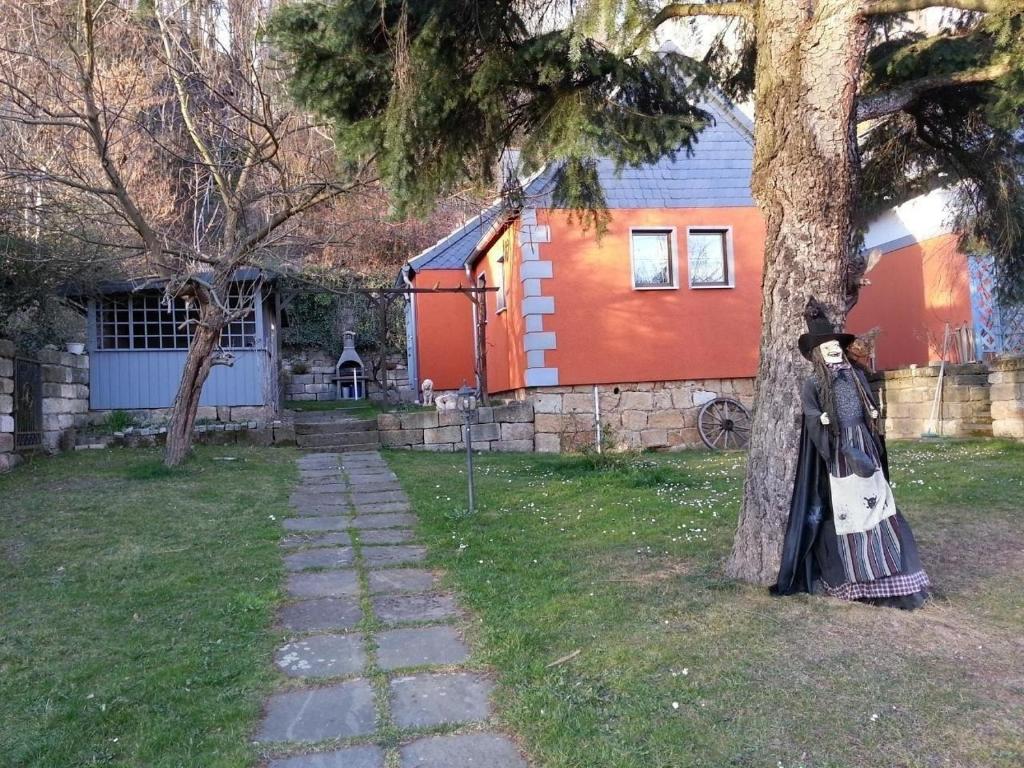 a person in a dress standing next to a tree at Gemütliches Ferienhaus in Pirna mit Großem Garten in Pirna