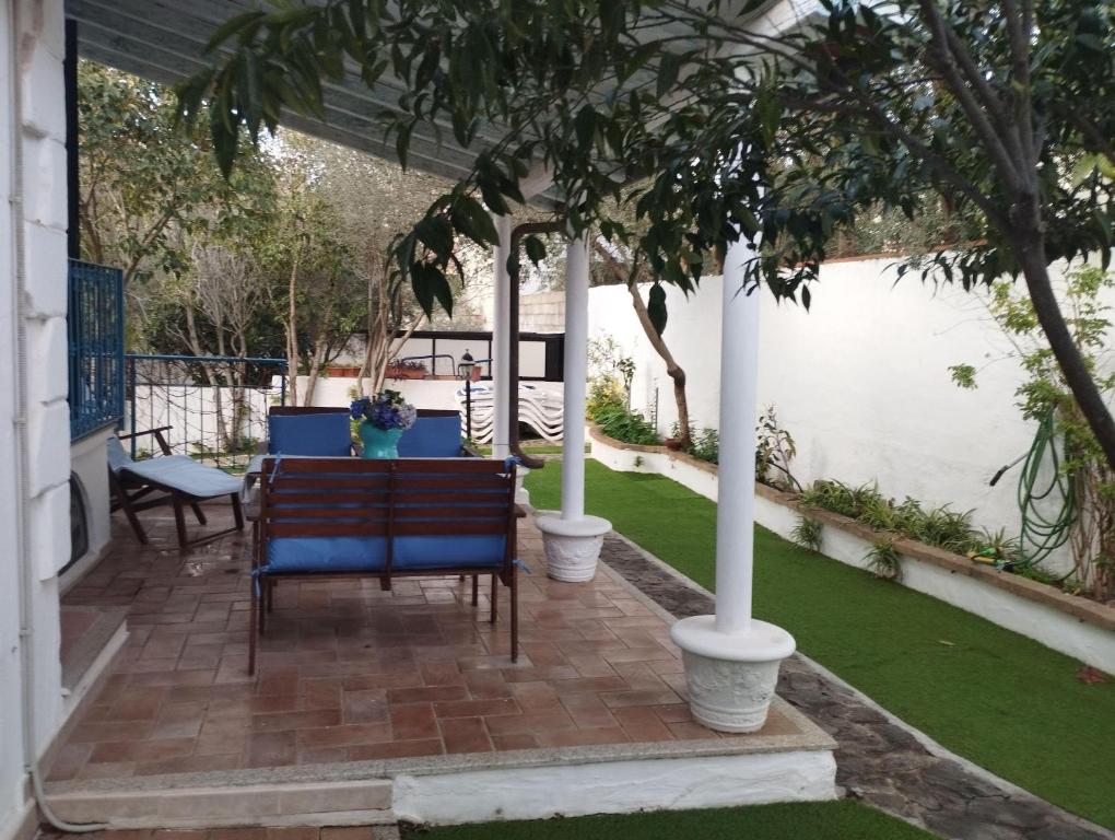 eine Terrasse mit 2 Stühlen, einem Tisch und Bäumen in der Unterkunft Edera Apartment# Tanaunella# Budoni# Beach in Budoni