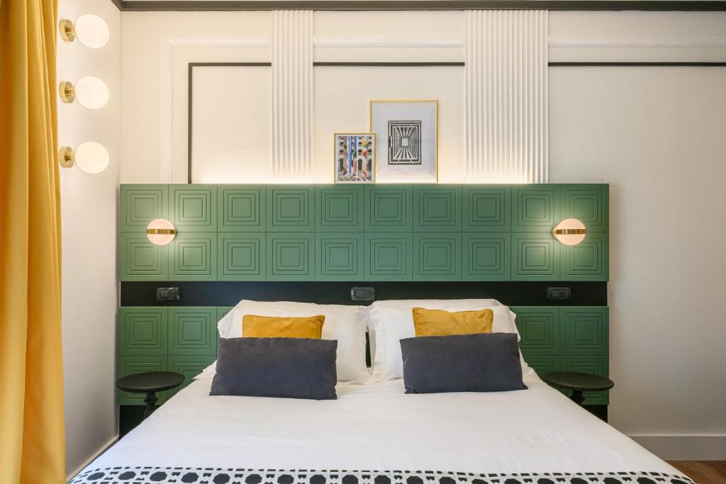 a bed with a green headboard and two pillows at Together Florence Urban Resort in Florence