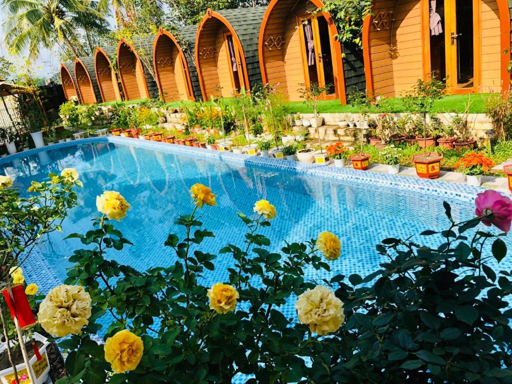 a swimming pool with a bunch of flowers next to it at BUNGALOW DANANG Healing Homestay 