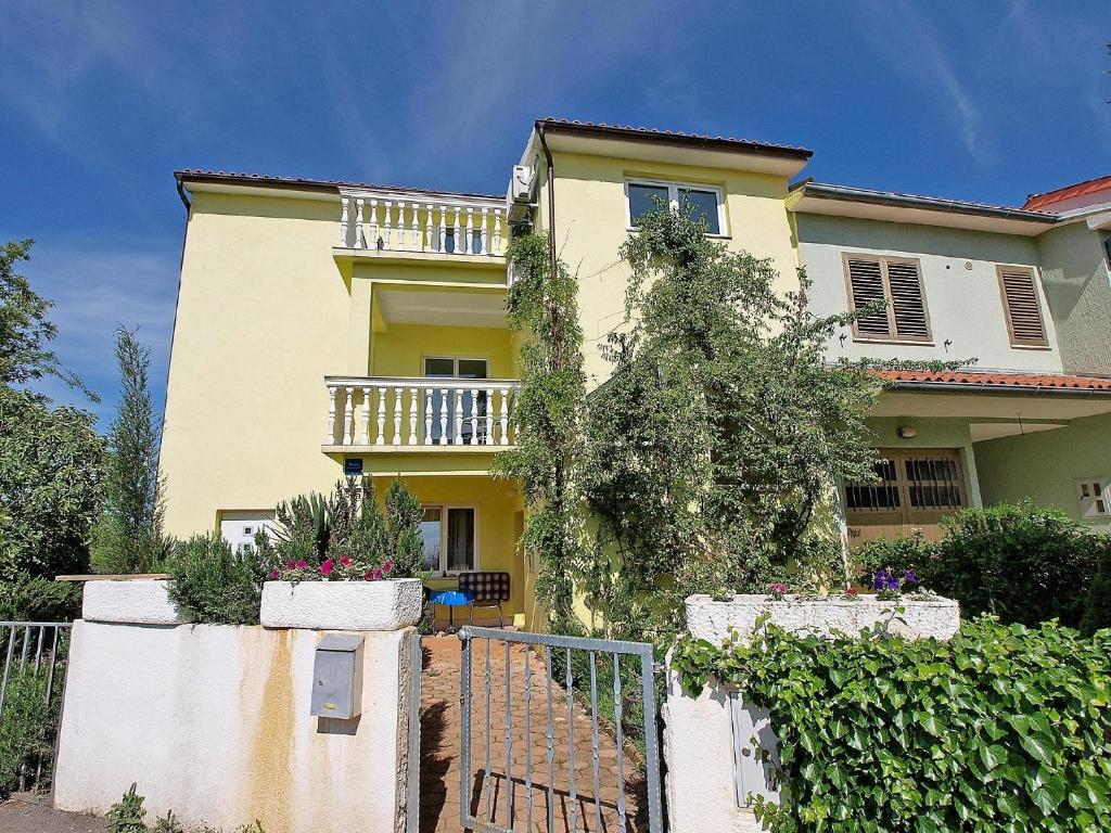 ein gelbes Haus mit einem Zaun davor in der Unterkunft Studio für 7 Personen ca 80 qm in Stinjan, Istrien Istrische Riviera in Štinjan