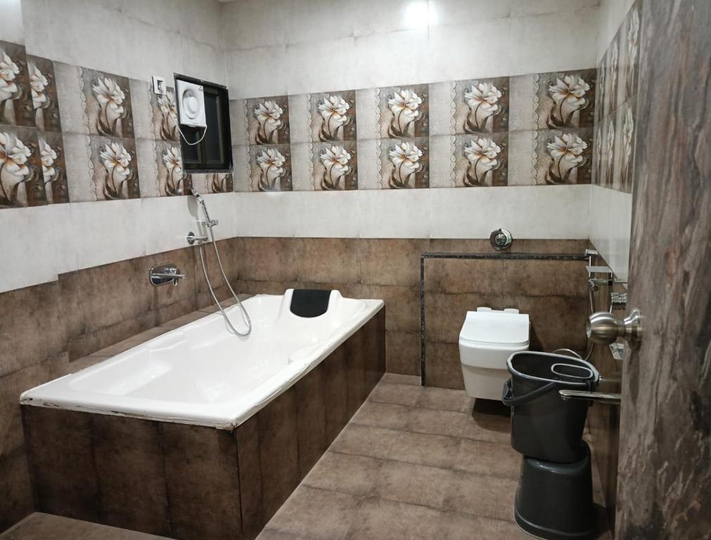 a bathroom with a bath tub and a toilet at HOTEL E CLASSICO in Bhavnagar