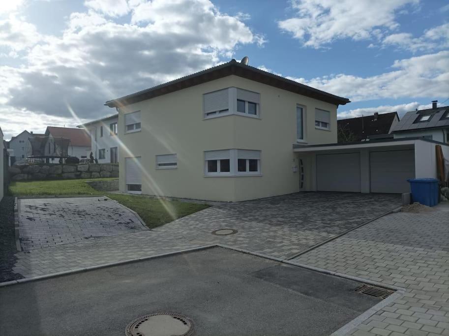 a white house with a garage and a driveway at Stadtvilla Wildeck. Ganzes Haus in Dietingen